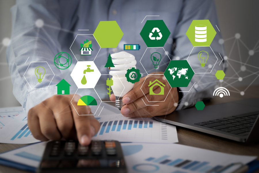 businessman working at desk with sustainability icons over image